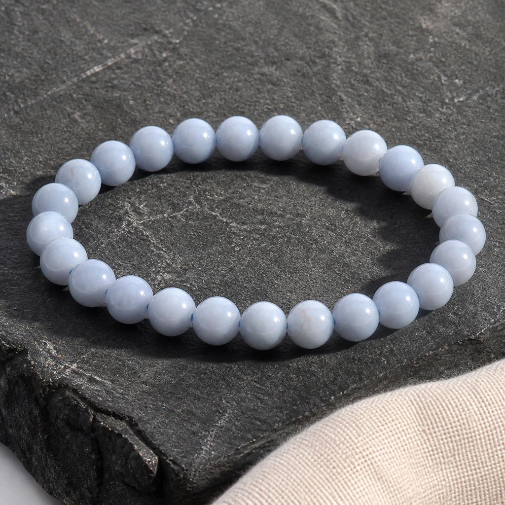 Bracelet en angélite 8 mm - 16 à 18 cm, présentation sur une surface sombre contrastée