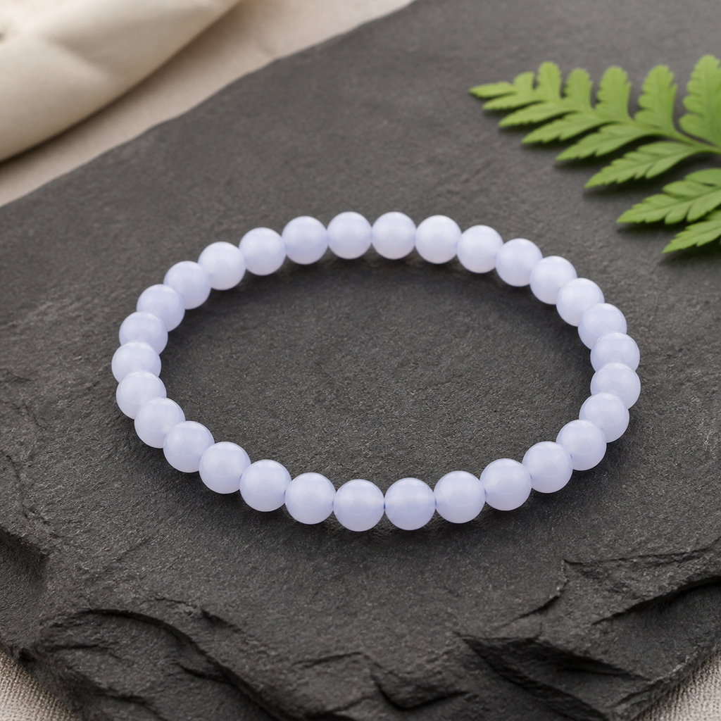 Bracelet en calcédoine bleue de Namibie - Perles de 6 mm, présentation sur une surface sombre contrastée