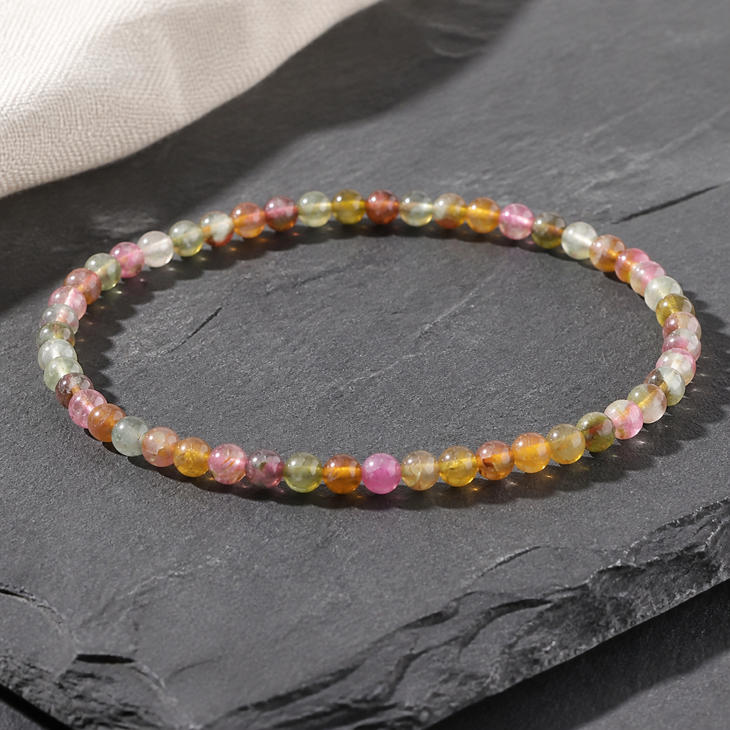 Bracelet en tourmaline multicolore 4 mm - 16 à 18 cm, présentation sur une surface sombre contrastée