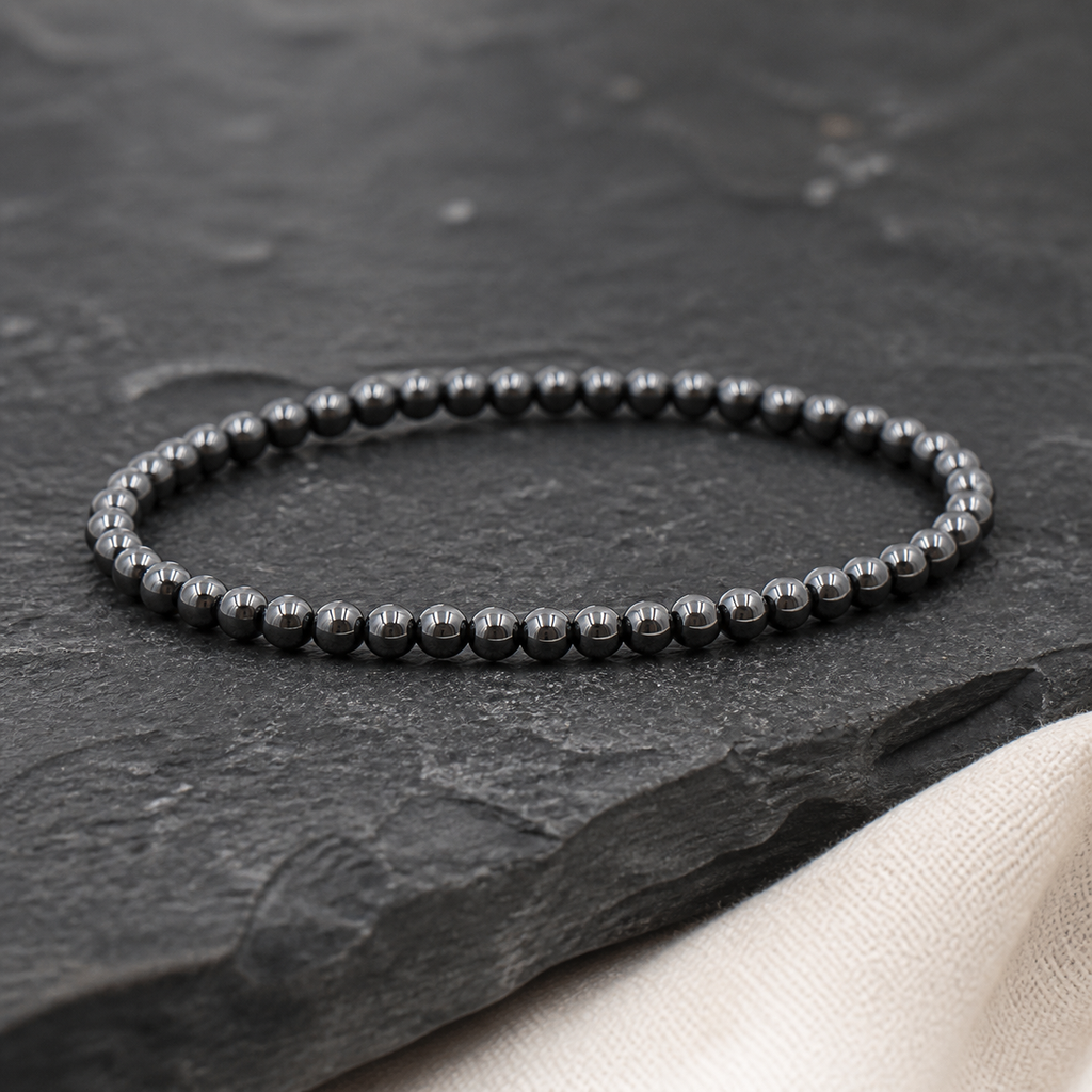 Bracelet fin en hématite - Perles de 4 mm, présentation complète sur fond sombre contrasté