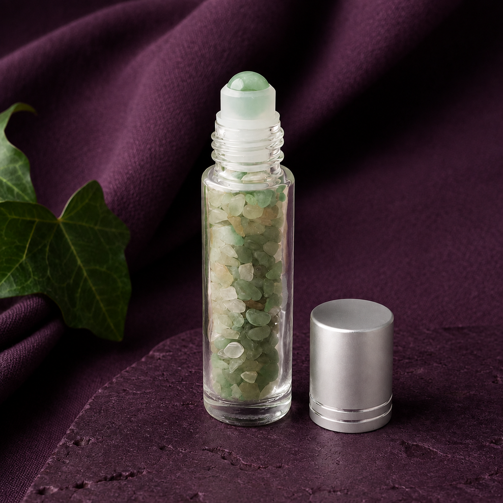 Flacon roll-on en aventurine verte sur pierre prune près d’une feuille