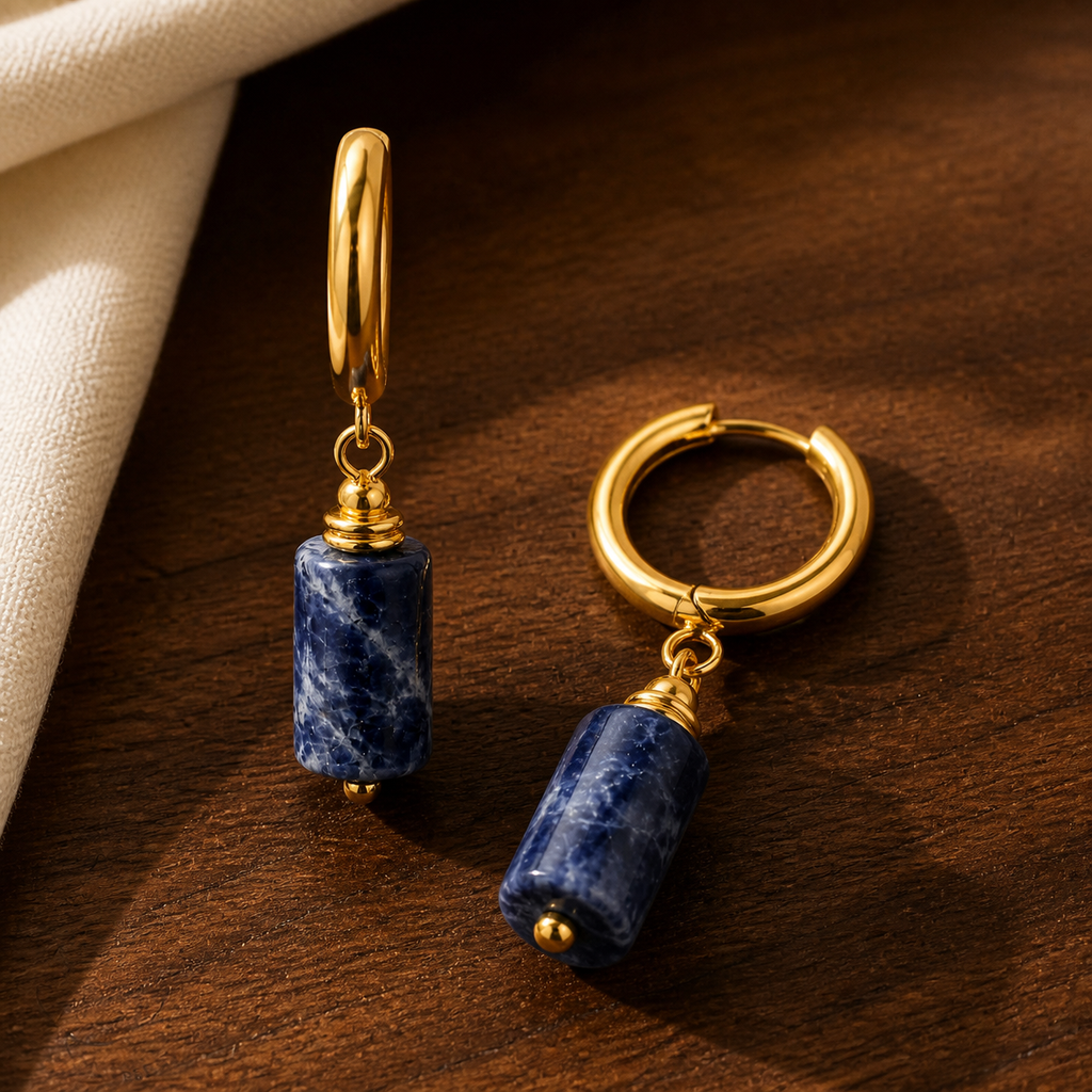 Boucles d'oreilles dorées en sodalite - 36 mm, présentation sur une surface sombre contrastée
