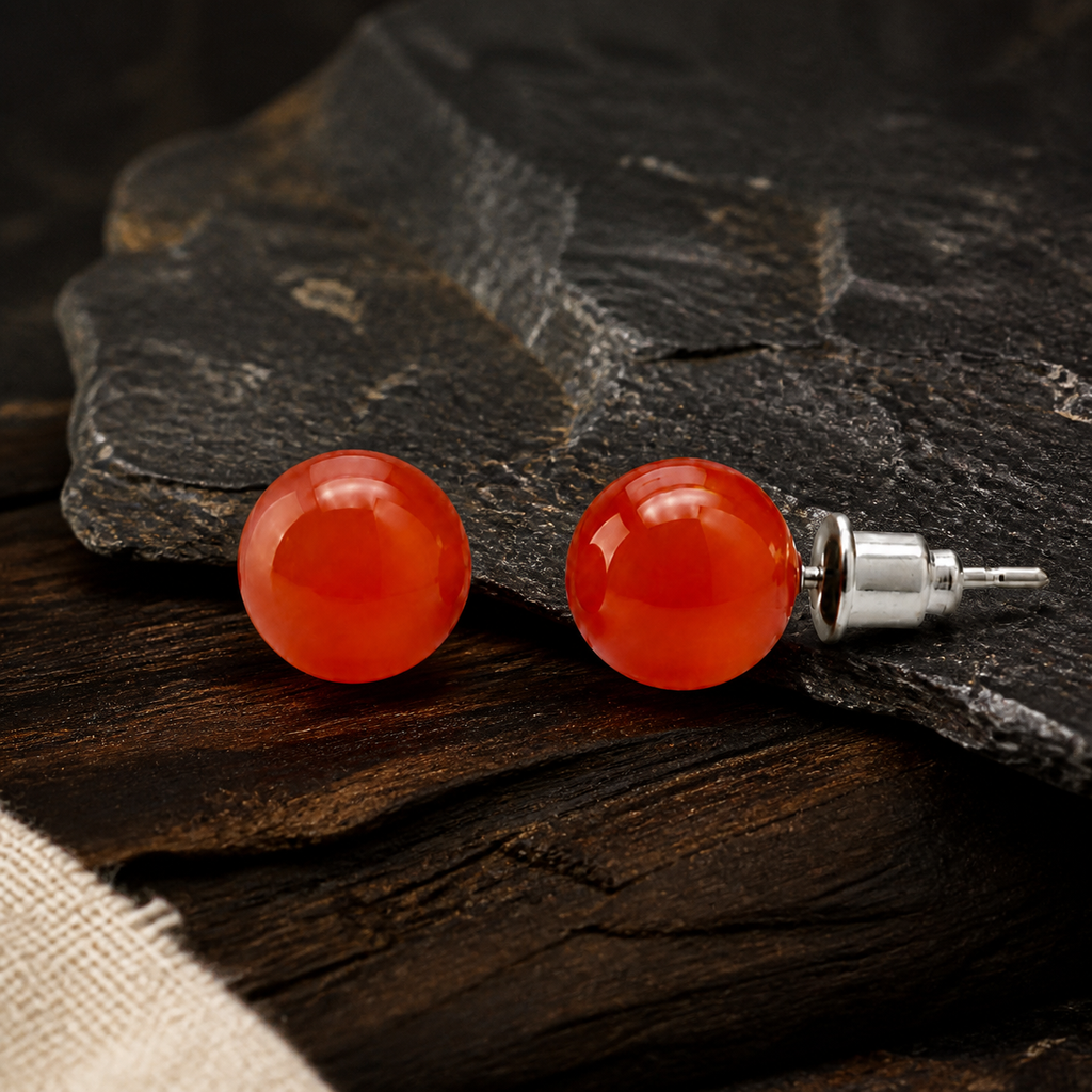 Boucles d'oreilles puces en cornaline 8 mm, présentation sur une surface sombre contrastée