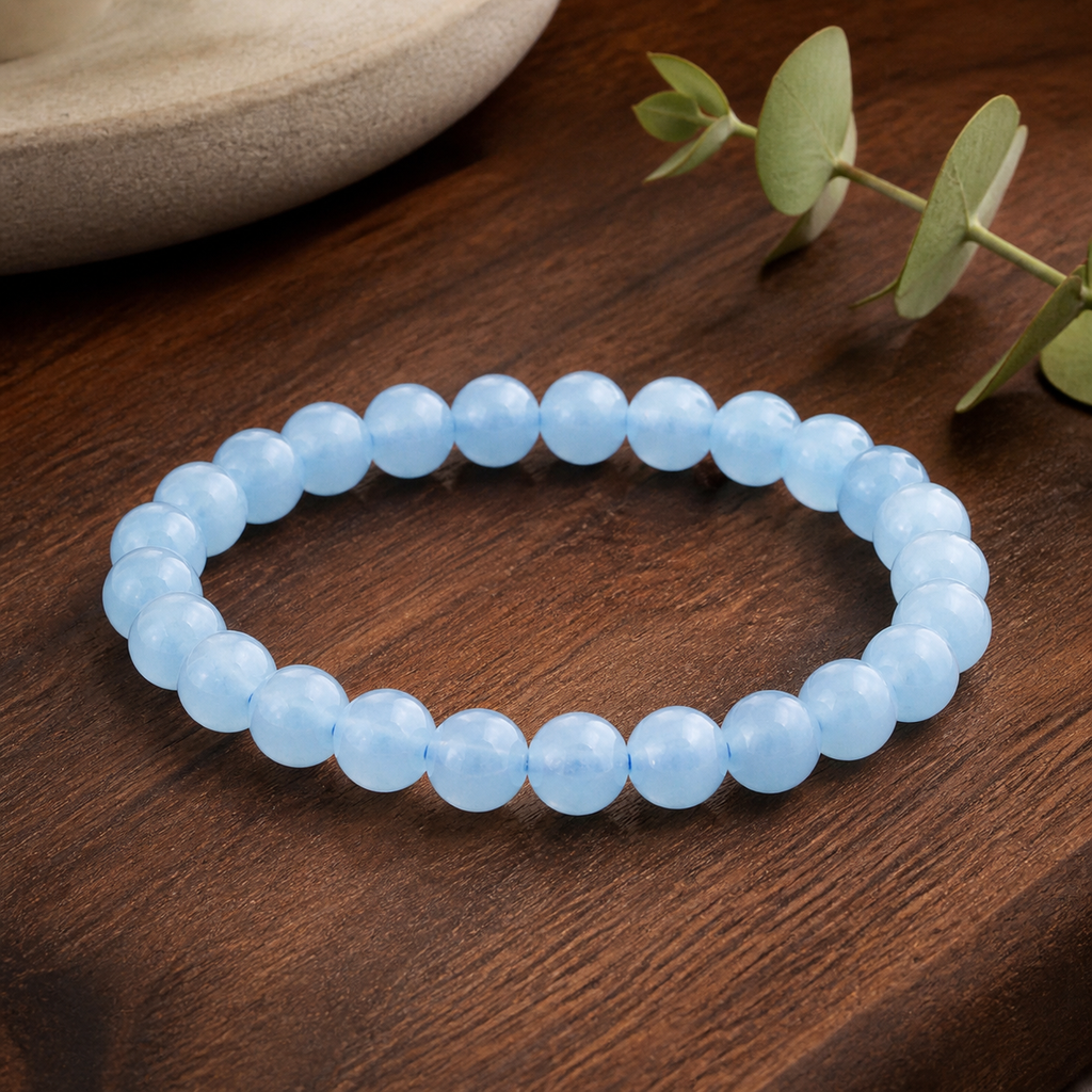Bracelet en aigue-marine chauffée du Brésil - Perles de 8 mm, présentation sur une surface sombre contrastée