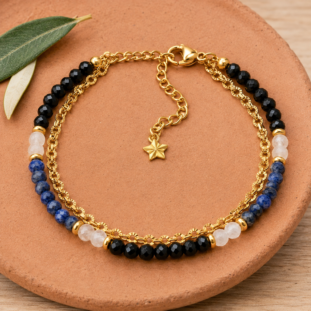 Bracelet doré en lapis-lazuli, spinelle et cristal de roche en nature morte près d’un feuillage