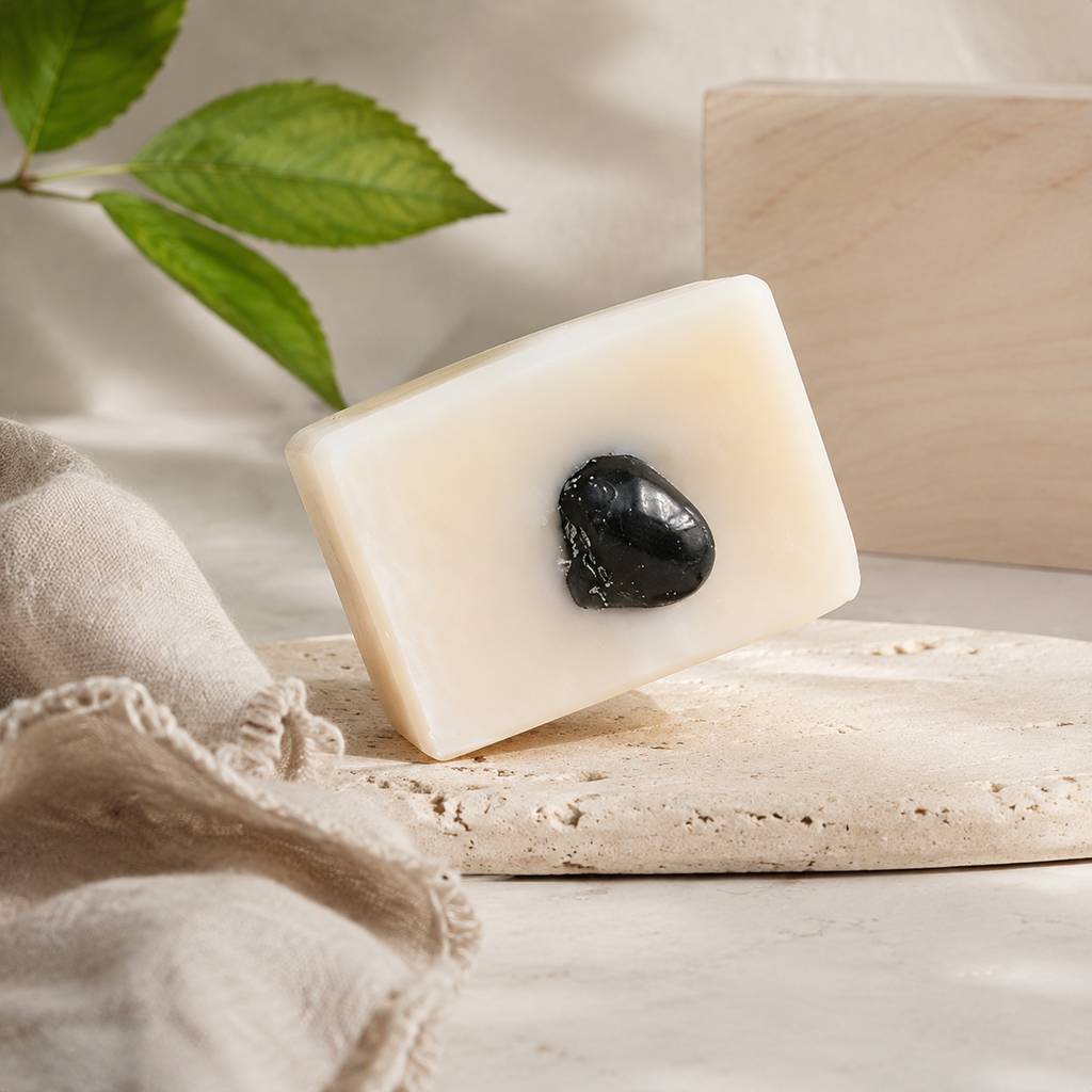 Savon framboise sur un support sombre près d’un élément végétal