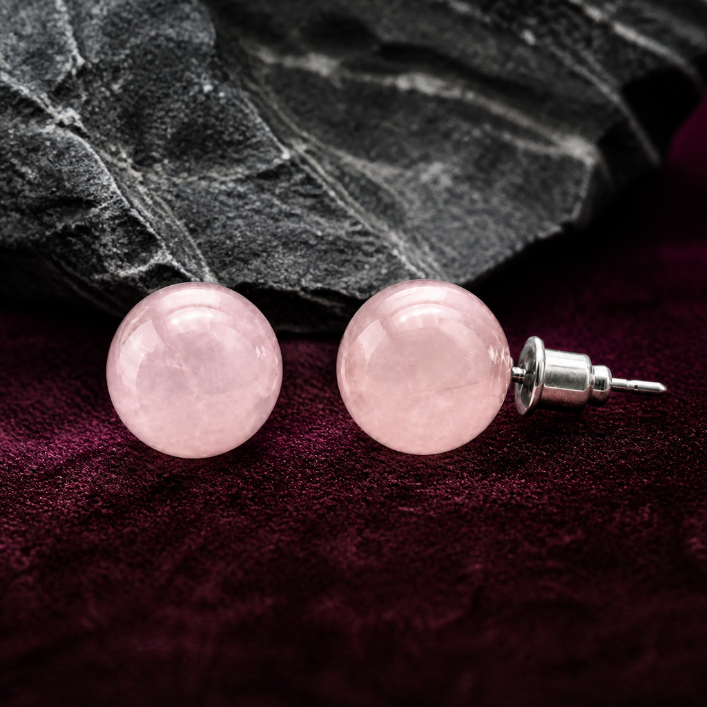 Boucles d'oreilles puces en quartz rose 10 mm, présentation sur une surface sombre contrastée