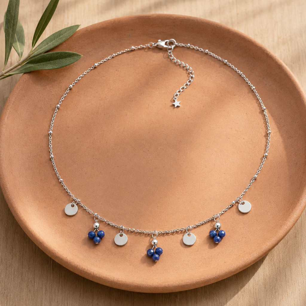 Collier argenté en sodalite à pampilles en nature morte près d’un feuillage