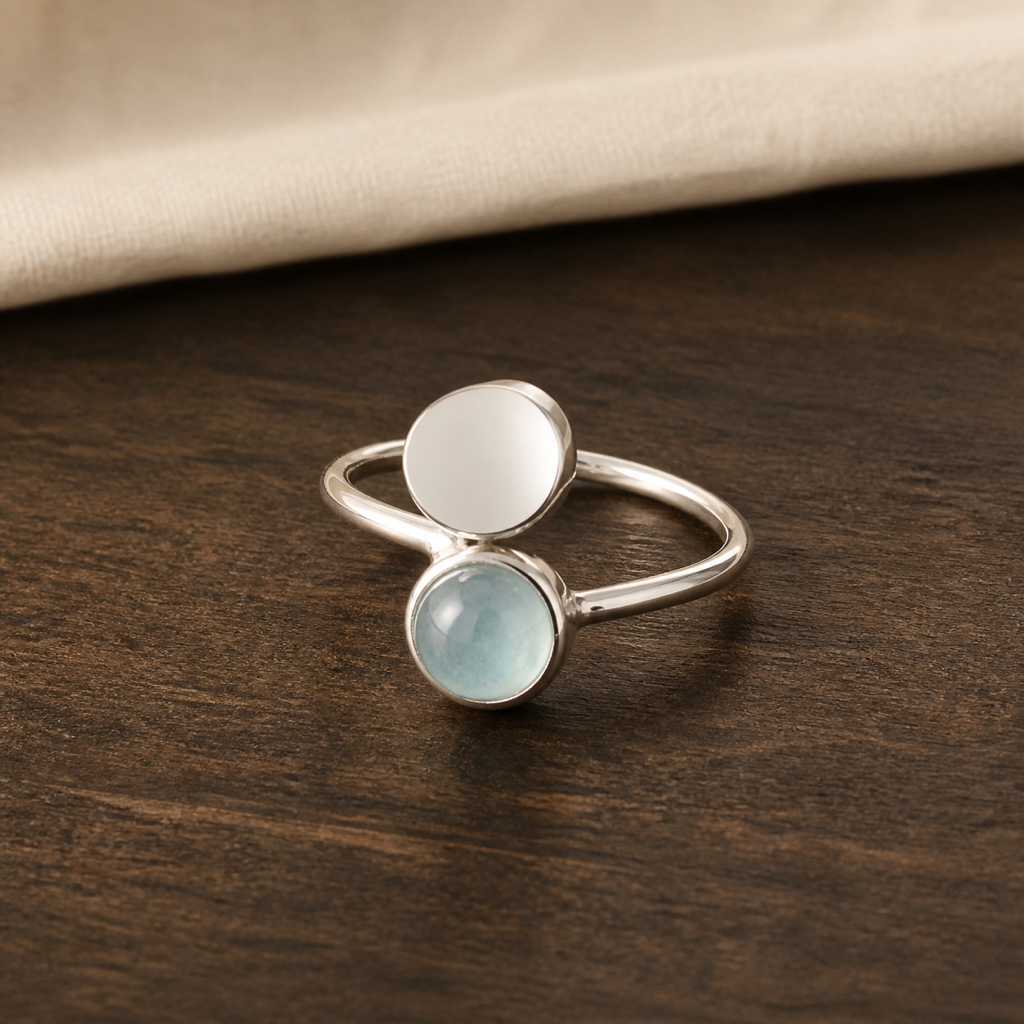 Bague ouverte en argent 925 et aigue-marine sur bois sombre contraste