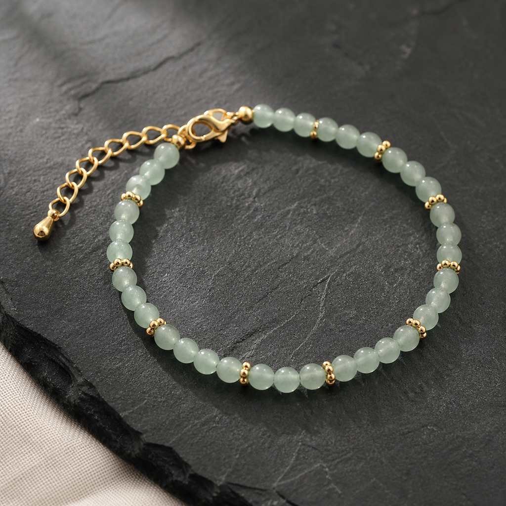 Bracelet Halo doré en aventurine verte 4 mm, présentation sur une surface sombre contrastée