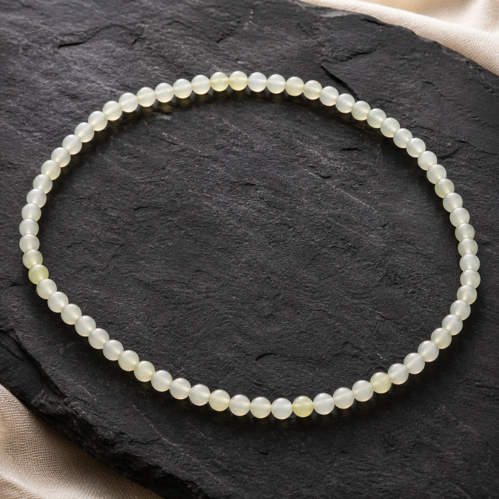 Collier en jade de Chine 6 mm - 45 cm, présentation sur une surface sombre contrastée