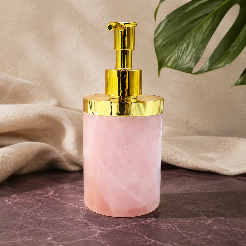 Distributeur en quartz rose sur pierre prune avec lin et feuille verte