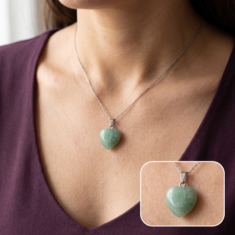 Pendentif cœur vert porté sur un haut prune avec détail agrandi de la pierre