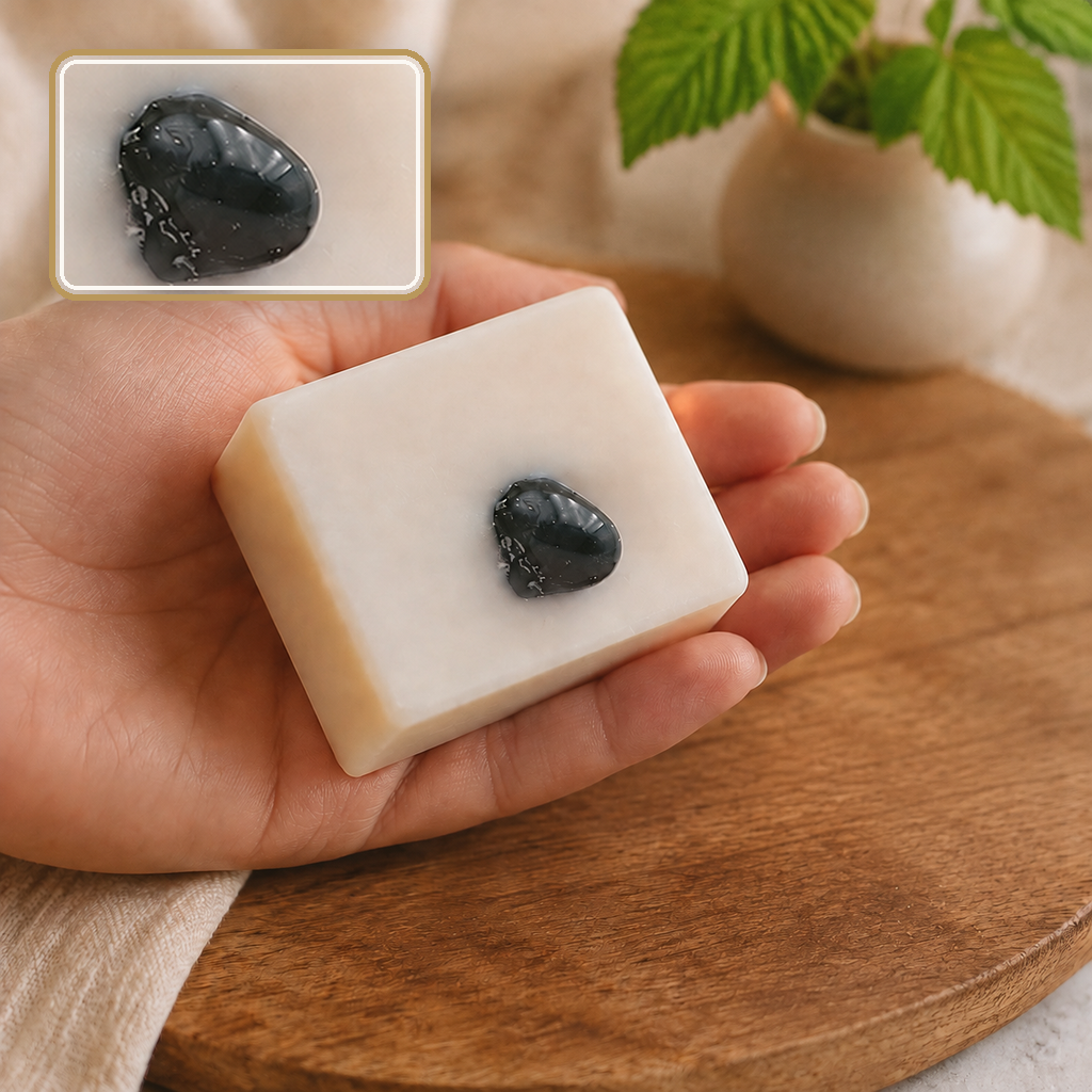 Savon framboise tenu au-dessus du bois près d’une plante, détail de la pierre sombre en encart