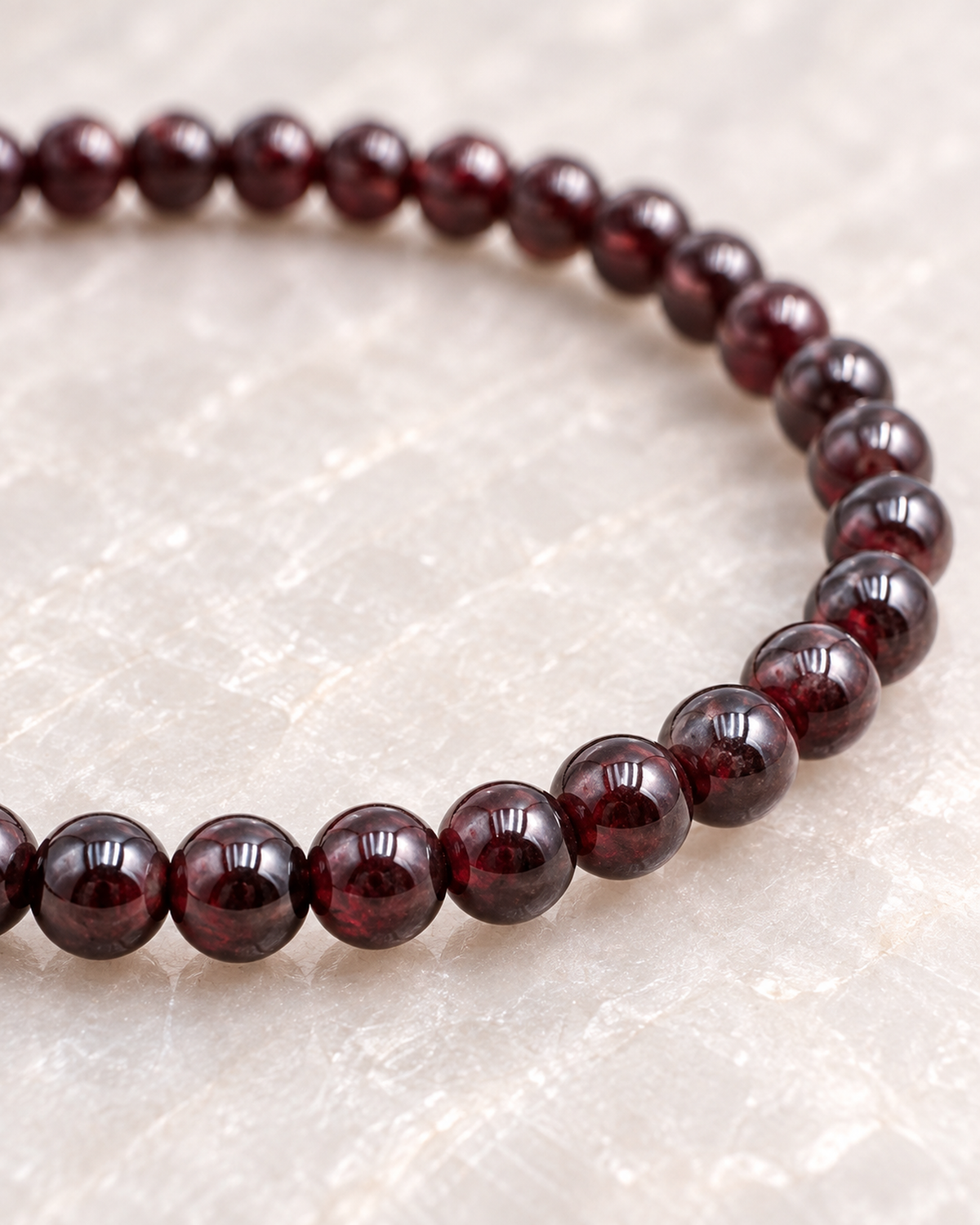 Macro des perles de grenat et de leur finition sur Bracelet en grenat rouge 4 mm