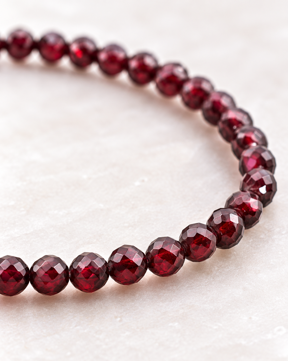 Macro des perles de grenat et de leur finition sur Bracelet facetté en grenat rouge 4 mm