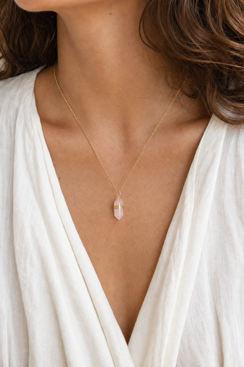 Collier bohème doré quartz rose porté au cou par un modèle