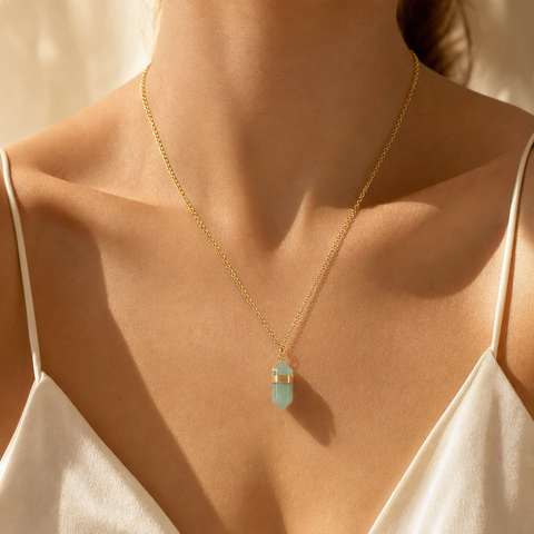 Collier aventurine verte doré porté au cou sur haut crème