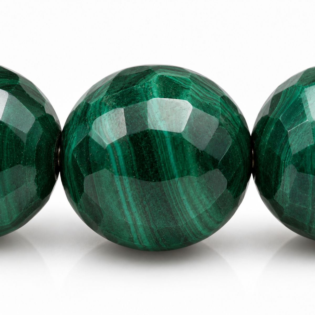 Gros plan d’une perle de malachite, facettes vertes et nuances naturelles