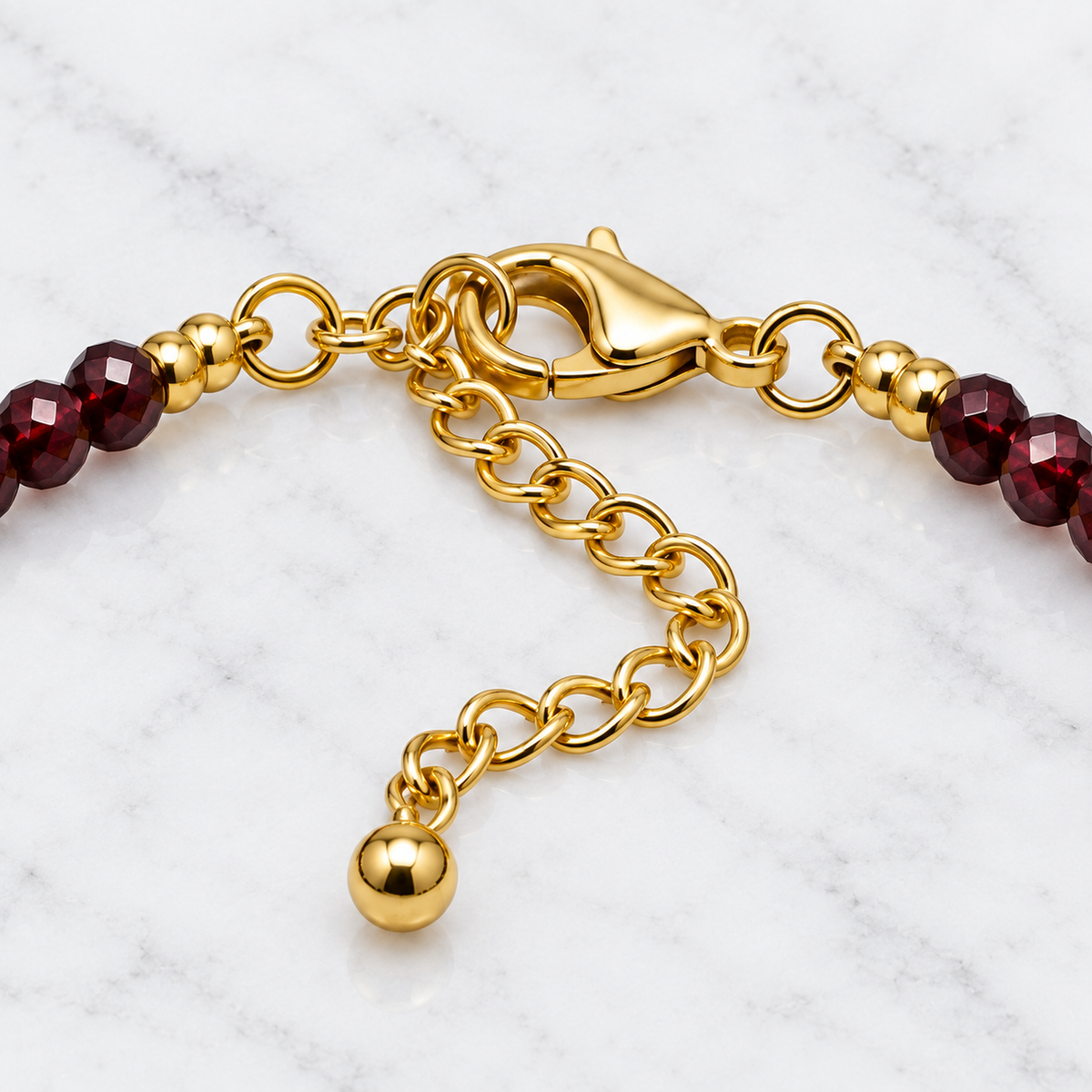 Fermoir mousqueton, anneaux et chaîne d'extension du bracelet doré en gros plan