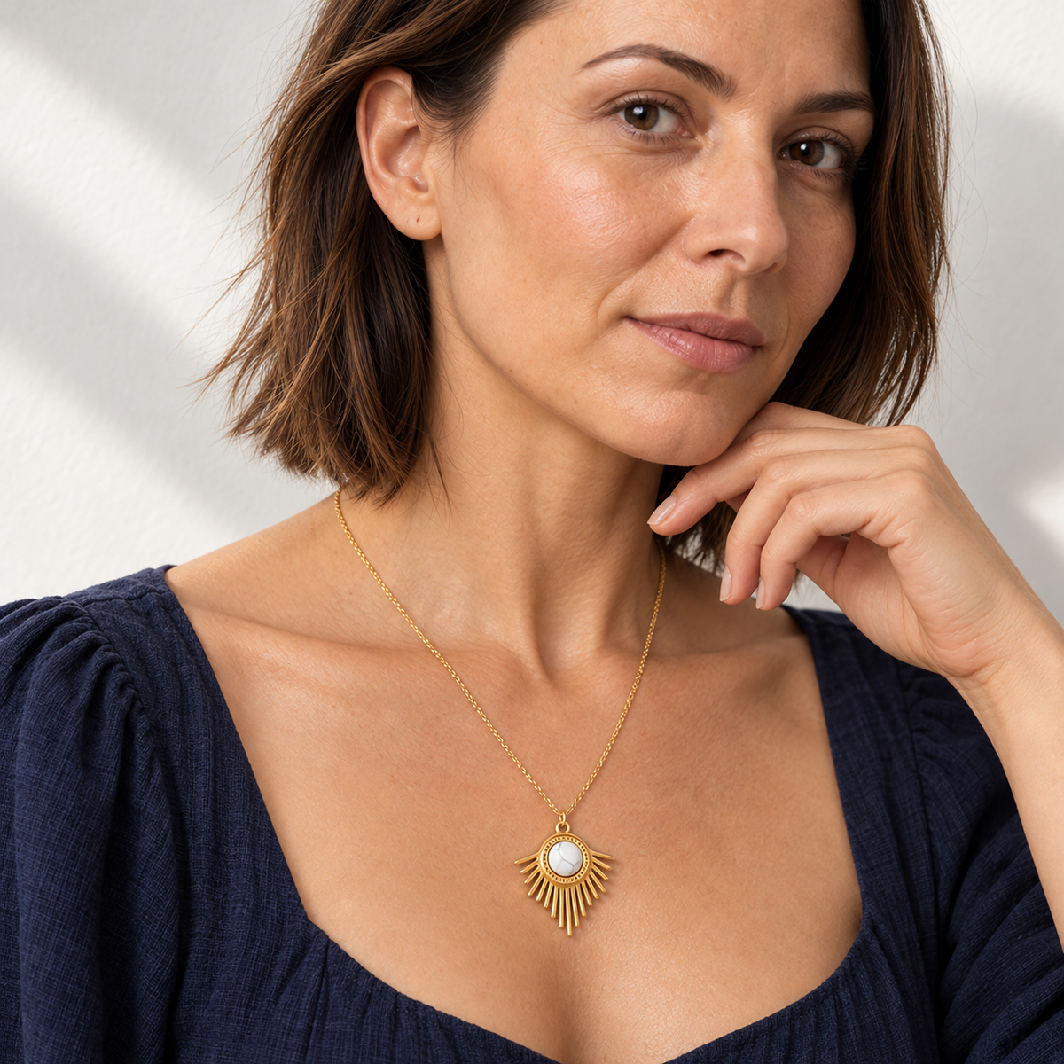 Collier doré en howlite blanche à pendentif rayonnant : décolleté en lumière de fenêtre