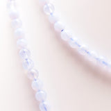 Détail des perles polies du collier en calcédoine bleue